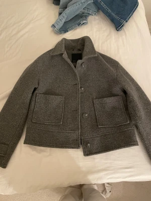 Grå kappa från lager 157 - Snygg grå rock från 157 i storlek XS, tillverkad i ullmaterial 💕💕 har dock ingen knapp på ena ärmen som jag visar på bilden 💕💕