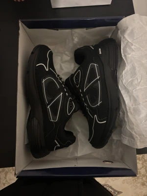 Svarta dior b30 - Säljer ett par helt nya svarta Dior b30 sneakers med vita kontrastdetaljer och snörning. Skorna har en chunky sula och meshpaneler för extra komfort. Märket syns tydligt på sidan, sulan och innersulan. Kommer med originalkartong och dustbag.