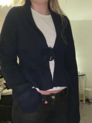 Mörkblå knyt kofta - Säljer denna super fina koftan från Nelly. Kofta är en knyt kofta och har lite volanger längst vid koftans nedre kant. Det är super skönt material och har en super fin mörkblå färg.🥰