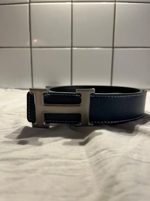 H bälte blå - Marinblått h bälte med silver märke. Pris kan diskuteras