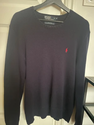 Stickad marinblå tröja Polo Ralph Lauren - Cotton Crew Neck Sweater Hunter Navy från Ralph Lauren. Superfin och klassisk stickad tröja som går att kombinera med de flesta outfits. Knappt använd och i fint skick.