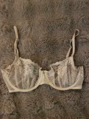 Vit bh från twilfit - Bhn har justerbara axelband med bygel och tunna meshpartier som ger en lyxig känsla. Perfekt för dig som gillar romantisk och elegant stil.