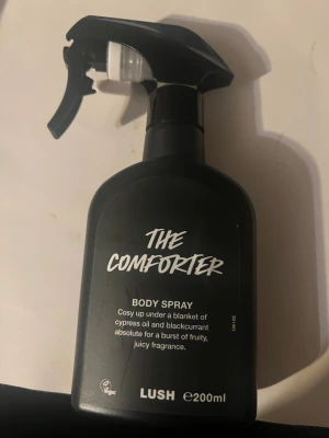 The Comforter Body Spray 200ml - The Comforter från Lush är en vegansk body spray med cypressolja och svartvinbärsextrakt för en fruktig, juicy vibe. Tillverkad i England. Volym: 200ml. Perfekt för dig som vill ha en söt och unik doft som sticker ut.