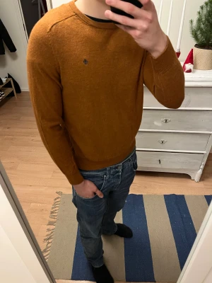 Brun merinoull stickad tröja från Morris (S) - Snygg brun stickad tröja från Morris med rund hals och diskret broderad logga på bröstet. Tröjan har ribbade muddar vid ärmslut och nederkant, och är långärmad. Perfekt för dig som gillar klassisk stil med en modern touch. Storlek i nacken är XL men den sitter som en Small, väldigt fin färg och skick! Hör av dig gällande frågor