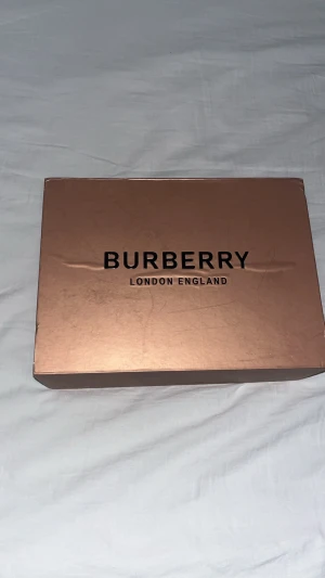 Burberry axelväska - Säljer en snygg axelväska från Burberry med det ikoniska rutmönstret i beige, svart och rött. Den är knappt använd jätte bra skick. Pris kan diskuteras!
