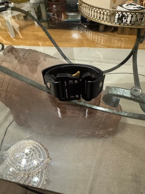 1017 ALYX 9SM Leather bracelet - Tech meets luxury this season with ALYX's small buckle cuff bracelet, rendered in a tactical black colourway. A bold addition to their rollercoaster buckle accessory roster, the New York based label share a leather bracelet complete with the iconic buckle. Robust and chunky, the tactical look of the bracelet offers a distinctive aesthetic that capitalises on the contemporary trend of war-core. Finished with printed branding, the one-size-fits-all accessory packs plenty of attitude into a small p