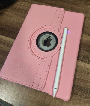 Apple iPad med penna och rosa fodral - Snygg Apple iPad i gott skick med rosa roterande fodral och medföljande penna. Skärmen ser ut att vara fri från sprickor och fodralet skyddar bra. Perfekt för studier, anteckningar eller underhållning. Laddare medföljer ej till ipaden. 9.7tum 2018 gen 6th. 