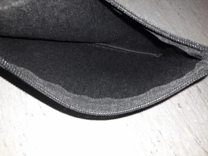 Svart Louis Vuitton kuvertväska i skinn - Snygg svart kuvertväska från Louis Vuitton med klassiskt monogrammönster i relief. Väskan har en avtagbar handledsrem och är tillverkad i strukturerat skinn. Perfekt storlek för mobil, kort och småsaker. Stängs med dragkedja upptill.