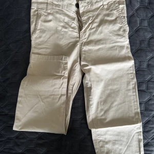 Beige byxor från Zara, stl 34 - Snygga beige byxor från Zara med klassiska sidfickor och raka ben. Byxorna är tillverkade i mjuk bomull och har en avslappnad passform. Perfekta för en chill och stilren look.