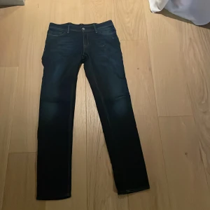 Acne Studios jeans mörkblå - Mörkblå jeans från Acne Studios Blå Konst, tillverkade i Italien. Klassisk femficksmodell med raka ben och diskreta kontrastsömmar. Snygg minimalistisk design och stilren passform, perfekta till många olika looks.