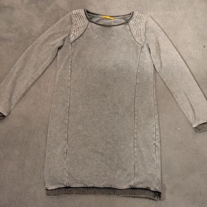 Grå klänning med nitar från BOSS - Grå långärmad klänning från BOSS med coola silvriga nitar på axlarna. 