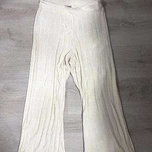 Ribbade vida byxor  - Snygga cremefärgade ribbade byxor  med bred resår i midjan och vida ben. Byxorna är mjuka och stretchiga.