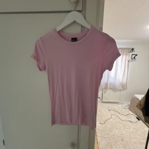 Ljusrosa t-shirt från Gina Tricot - Populär tight t shirt från Gina i asskönt material använd fåtal gånger jätte bra skick 