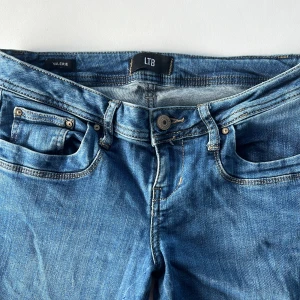  LTB Jeans  - Snygga blå jeans från LTB med klassisk femficksdesign och kontrastsömmar. Modellen har bootcut-ben och låg midja, vilket ger en avslappnad och trendig look. Modell Valerie Storlek: W27 L34 Går med på lägre pris vid snabb affär💙 Obs! Jeansen är köpta av tidigare tjej och hon hade sytt in dessa utan att klippa av tyget. Jag har sprättat upp det så att byxorna har sin original storlek. Inga stora synligheter men vill medge detta.