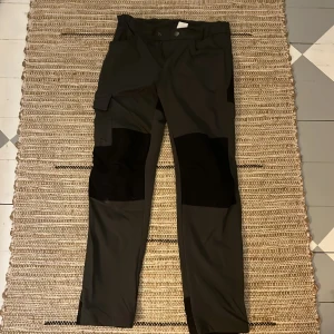 Svarta och gröna vandrings byxor. - Vandrings byxor från Lindex med en ficka på sidan av benet, det är två reglerings band vid midjan.