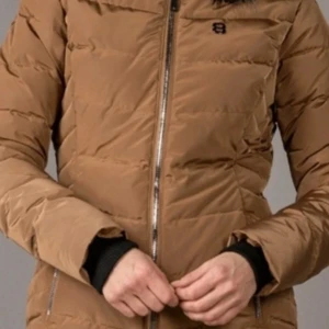 Brun pufferjacka med dragkedja  - Snygg brun pufferjacka från 8848 Altitude med quiltad design och hel dragkedja framtill. Jackan har långa ärmar och två sidofickor med dragkedja. Perfekt för kyligare dagar och enkel att matcha med olika outfits.