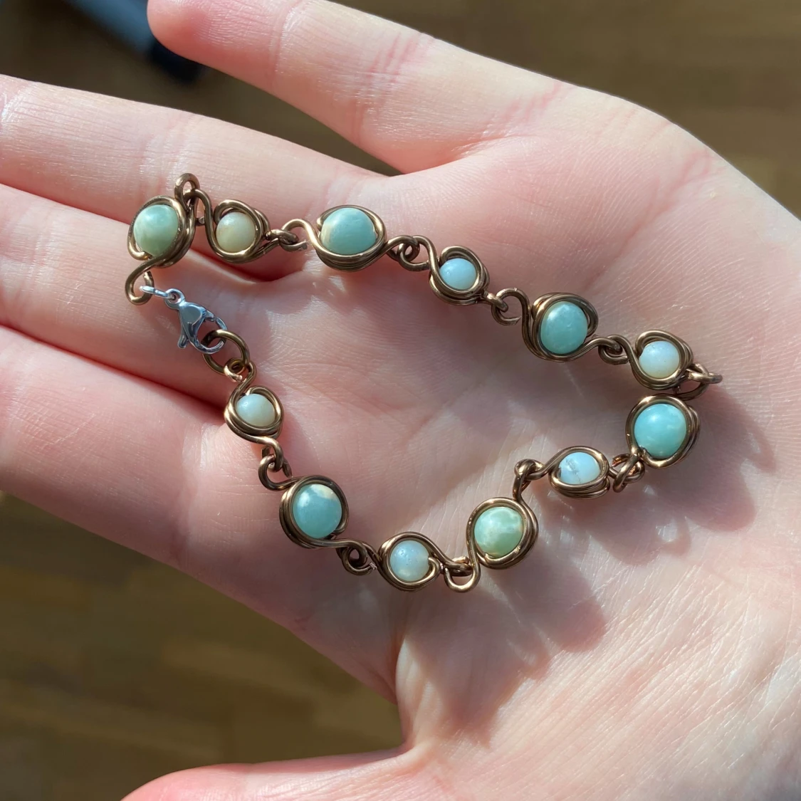 Armband med ljusgröna/ljusblå stenar och koppartråd