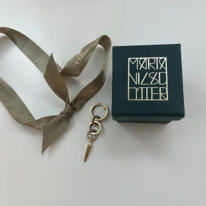 Guldörhänge Maria Nilsdotter - Unikt örhänge i guld från Maria Nilsdotter med tre ringar och en spetsig hängande detalj. Snyggt och edgy design som sticker ut, perfekt för dig som gillar statement-smycken. Kommer med original ask och band.