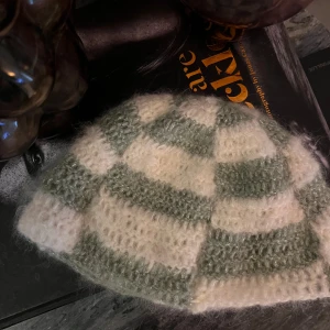 Rutig stickad beanie  - Turkos och vit självvirkad kort beanie med silver detaljer. Storlek M (passar 56cm, men är stretchig) 