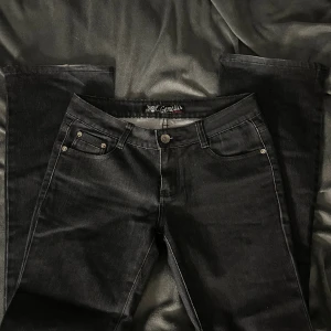 Svarta bootcut jeans från Gemello - Svarta jeans från Gemello med klassisk femficksdesign och snygga detaljer på bakfickorna. Jeansen har bootcut-modell och är tillverkade i ett stretchigt denimtyg som ger en bekväm passform. Perfekta för dig som gillar en tidlös look.