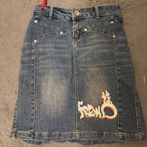 Blå jeanskjol med broderier - Säljer en cool blå jeanskjol från Cherry Ann med broderade detaljer. Skriv gärna för fler bilder🥰