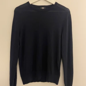 Svart stickad tröja från Uniqlo XS - En stilren svart stickad tröja från Uniqlo i storlek XS. Tröjan har rund halsringning och långa ärmar, perfekt för lager-på-lager. Enkel och klassisk design som funkar till allt. Materialet är mjukt och skönt mot huden.