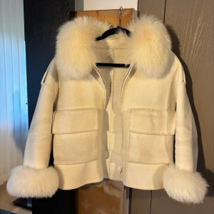 Vit pälsjacka - Säljer min vita pälsjacka, den ser gulare ut på bilderna än vad den är, bara att be om fler bilder om ni är intresserade. Använt några gånger men fortfarande i bra skicka och inga fläckar.