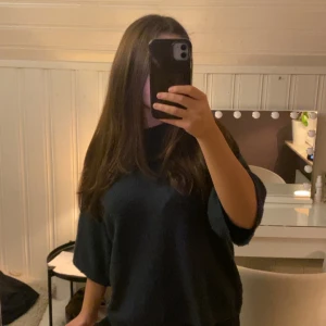 Mörkblå stickad tröja med loose fit - Säljer en svart stickad tröja med loose passform och trekvartsärm. Perfekt för dig som gillar en chill och avslappnad stil. Tröjan har en enkel design utan detaljer och passar dig som vill ha något bekvämt och snyggt. 