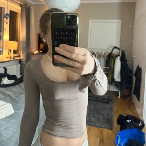 Beige långärmad topp Gina Tricot XXS - Supersnygg beige långärmad topp från Gina Tricot i storlek XXS. Modellen är tight med croppad passform. Mjuk och stretchig i bomullsmix, perfekt för dig som gillar stilrena och trendiga plagg. I ena armen är den trasig men syns inte när man har den på sig 