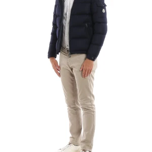 Svart Moncler montgenevre jacka - Säljer en svart pufferjacka från Moncler med avtagbar huva och klassisk logga på ärmen. Jackan har quiltad design, dragkedja framtill och praktiska fickor. Insidan har en unik serietidningsetikett. Perfekt för kalla dagar och riktigt snygg stil.