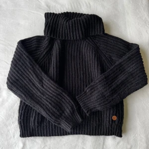 Svart stickad tröja - Svart polotröja från Ü med ribbstickning och polokrage, storlek: 140. Fraktar inom 24h!