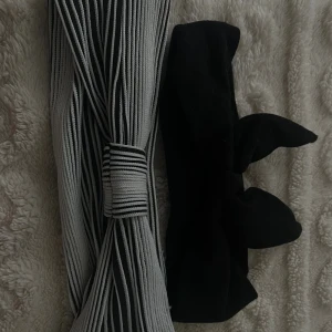 Två diadem, svart och randigt - Säljer två snygga diadem. Ett svart diadem med rosett och ett svartvitt diadem med coola ränder och twistad detalj framtill. Perfekta accessoarer för att lyfta din look och hålla håret på plats.