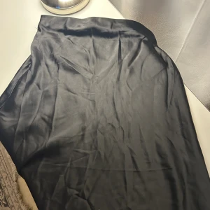 Svart satinkjol  - Svart satinkjol i storlek XS från bikbok. 