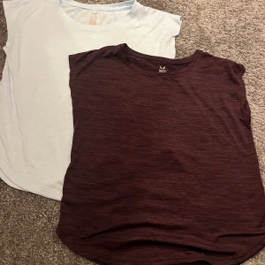 2-pack SOC t-shirts i vinrött och ljusblått - Två snygga t-shirts från SOC i storlek 146-152. En är vinrödmelerad och den andra ljusblå, båda med rund hals och ärmlös design. Perfekta för träning eller chill dagar. Materialet är lätt och andas, vilket gör dem sköna att bära.