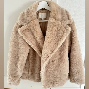 Beige fuskpäls/teddy jacka från H&M - Supermjuk och fluffig teddyjacka från H&M i beige färg. Toppen skick då den endast är använd fåtal gånger. Mellanlängd för mig som är 176 cm lång. 