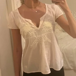 Rosa blus med broderi från Odd Molly - Säljer en supersöt vit blus från Odd Molly med v-ringning och korta ärmar. Säljer pga den är lite för stor för mig som vanligtvis bär xs-xxs i toppar🩷🩷skirv för mer bilder/frågor!