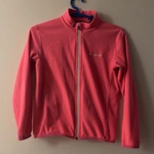 Rosa fleecejacka från Everest - Snygg rosa fleecejacka från Everest med hel dragkedja framtill och hög krage. Jackan har långärmade ärmar och är perfekt för lager-på-lager under kyliga dagar. Enkel design med diskret logga på bröstet.