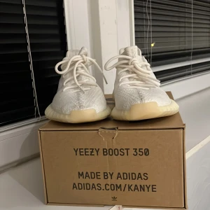 Adidas Yeezy Boost 350 Triple White - Säljer ett par Adidas Yeezy Boost 350 i färgen Triple White. Skorna har en stickad ovandel i vitt, rund tå, snörning och en tjock, ribbad sula i ljusbeige. Ikonisk och clean design signerad Kanye West, perfekt för dig som gillar streetwear och sneakers med hype. Använt kanske 1 gång. Storlek 40 men ryms också på 39!!