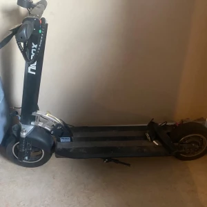 Nexx el-scooter - Stabil el-scooter från Nexx med digital display och robust ram. Utrustad med stora hjul och bred fotplatta för bekväm körning. Viss smuts och normalt slitage syns på plattan, men i övrigt gott skick. Perfekt för smidig pendling i stan. Det går dock ej att starta sparkisen, men när jag stoppar in laddare så står det att den laddar. Laddare ingår i köp 