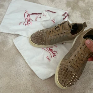 Christian Louboutin  - Vi säljer dessa tvärfeta beiga dojjor från Christian Louboutin med klassisk röd sula i storlek 43, skick 7/10. Skorna har snörning och är tillverkade i mocka med mesh-detaljer på sidorna. Perfekt för dig som vill sticka ut med exklusiv stil. 2 dustbags, extra snören och extra nitar kommer med köpet! Pris kan diskuteras vid snabb affär och vid fler frågor är det bara att skriva!