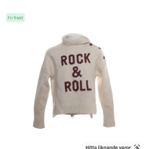 Zadig Vit polotröja med text Rock & Roll - OBS! Har fläckar på ärmen och en på fram som jag ej försökt ta bort Stickad Vit polotröja med vinröd text 'ROCK & ROLL' framtill. Tröjan har ribbade muddar, hög krage och dekorativa knappar på axeln. Perfekt för dig som vill sticka ut med en cool och bekväm stil.