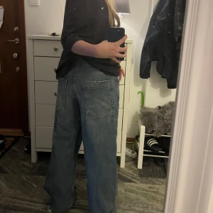 Streetstyle blåa baggy jeans  - Säljer ett par blåa baggy jeans från BDG Urban outfitters med riktigt breda ben och råa, fransiga benslut. Jeansen har klassisk femficksdesign, stora bakfickor och en cool tvättad look. Perfekta för dig som gillar avslappnad och trendig stil.