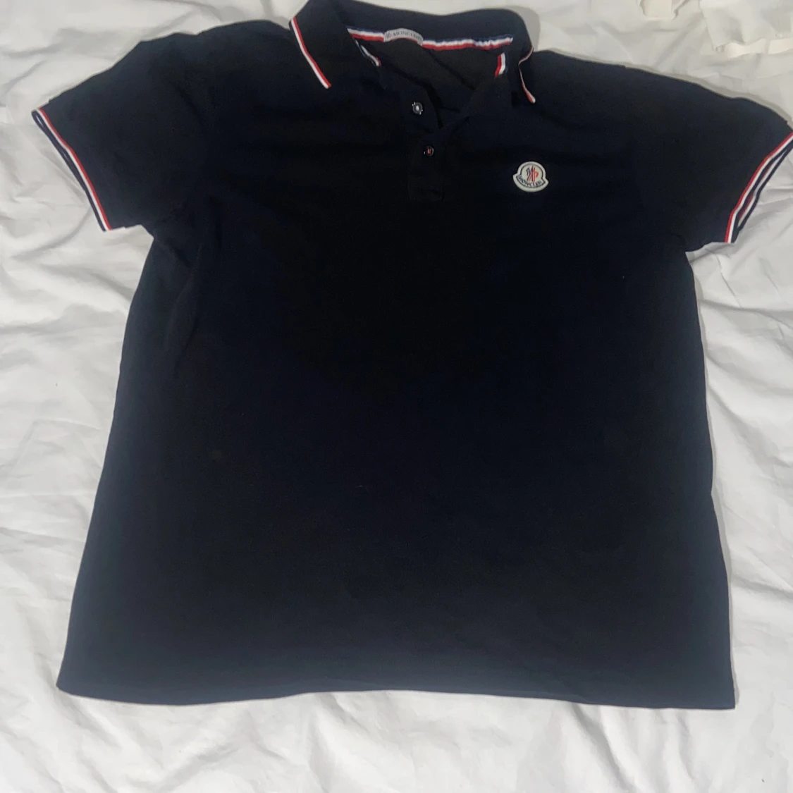 Svart Moncler pikétröja med röd/vit kant