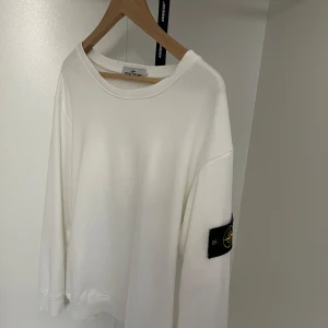 Stone Island sweatshirt i vitt och gult - Två stilrena sweatshirts från Stone Island, en i helvitt och en i klargult. Båda har klassisk rund hals, långa ärmar och den ikoniska loggan på vänster ärm. Perfekt för dig som gillar enkel men snygg streetwear.