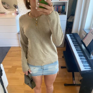 Säljer Beige stickad tröja!!! - Supermjuk beige stickad tröja med rund halsringning och ribbade muddar vid ärmslut och nederkant. Perfekt för lager-på-lager och enkel att matcha med både jeans och kjol. Långärmad och i klassisk, tidlös model