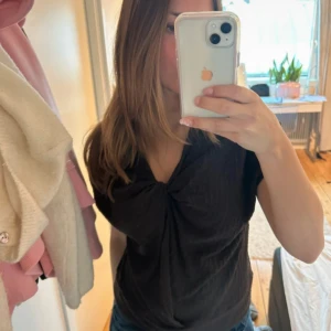 Brun omlottopp från Lindex - Säljer en brun omlottopp från Lindex i storlek M. Toppen har korta ärmar, v-ringning och en snygg twistad detalj framtill. Materialet är strukturerat och ger en cool känsla. Perfekt att styla med jeans eller kjol för en trendig look. Tröjan är sparsamt använd!