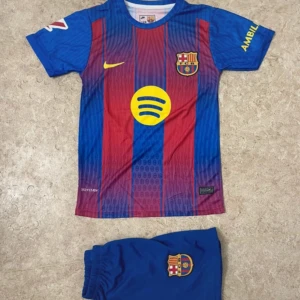 FC Barcelona Lamine Yamal matchtröja - Säljer en FC Barcelona matchtröja med Lamine Yamal och nummer 10 på ryggen. Tröjan är kortärmad, har klassiska blå och röda ränder, gula detaljer och klubbmärke på bröstet. Materialet är lätt polyester, perfekt för fotboll. Shorts med klubbmärke ingår.