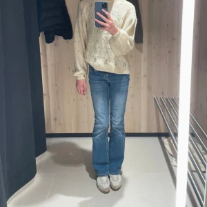 Blå lågmidjade bootcut jeans från ONLY, stl 30 - Snygga blå jeans från ONLY i bootcut-modell med klassisk femficksdesign. Jeansen har låg midja och är tillverkade i mjukt denimtyg med lätt slitning framtill. Perfekta för dig som gillar en avslappnad men trendig look.