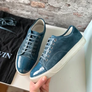 Lanvin cap toe Sneakers - Mycket bra skick, endast använda ett fåtal gånger. Köptes på Care of Carl och har kvitto. Väldigt ovanlig färg så passa på! Nypris ca 5000kr. Storlek 43.  Box+extra snören medföljer!. Självklart äkta - kolla bara recensionerna! Skriv för mer information🤝