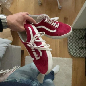 Röda Vans sneakers med vit sula - Säljer ett par snygga röda Vans sneakers med klassisk vit sula och vit sidostripes. Skorna har rund tå, platt sula och är tillverkade i mocka med vita snören. Står 41 men dessa är mindre i storleken skulle jag påstå, priset ej hugget i sten!